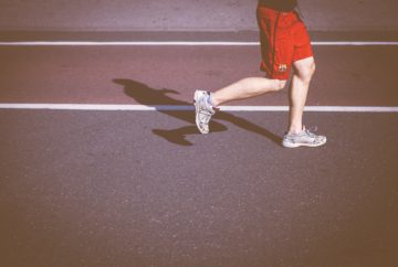 A man running with red pants on a track