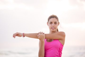 Woman in pink doing arm streaches